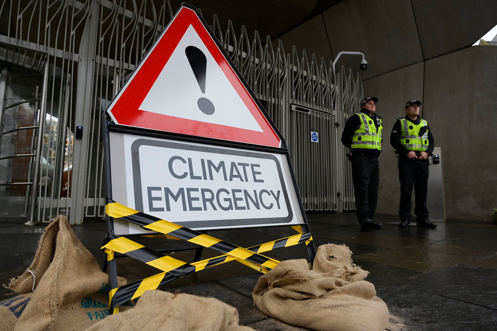 Photo of a sign reading Climate Emergency taken in Scotland