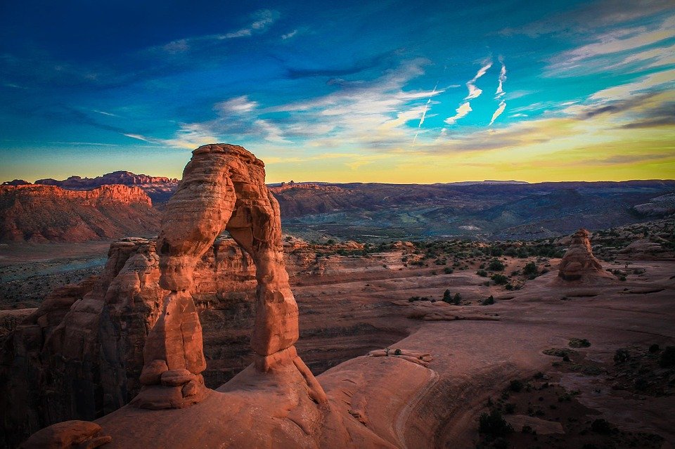 Stone arch formation and buttes in landscape view of outdoors