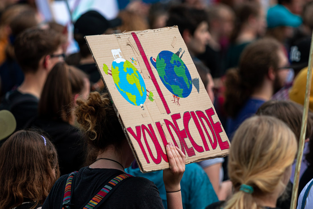 Image of climate change demonstrator holding a sign saying You Decide