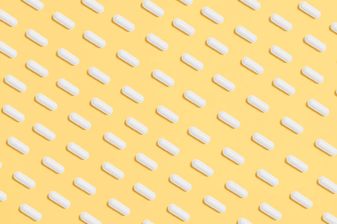 Image of pills aligned in a pattern on a yellow field
