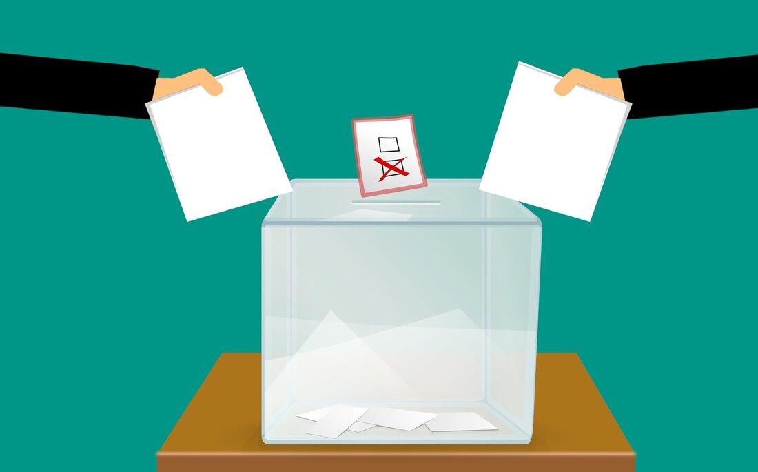 Image of paper ballots near a ballot box