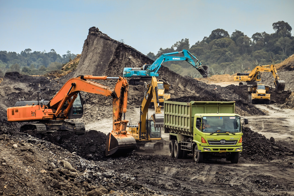 Heavy machinery and trucks transporting coal in a coal mine