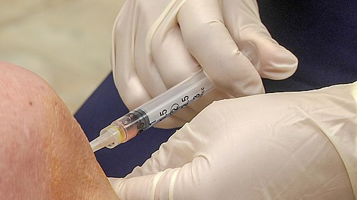 Image of a doctor administering a stem cell injection to a patient's knee