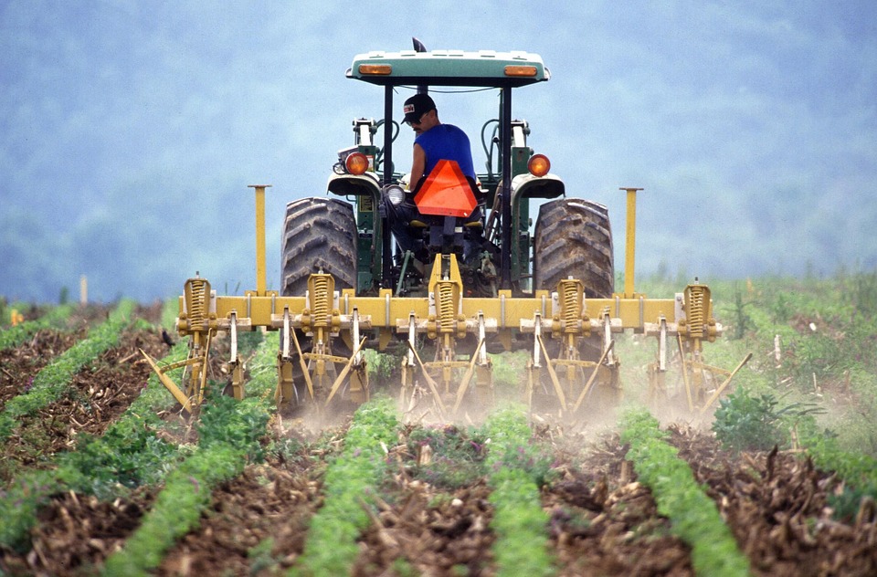 Farmer on a tractor tilling a field