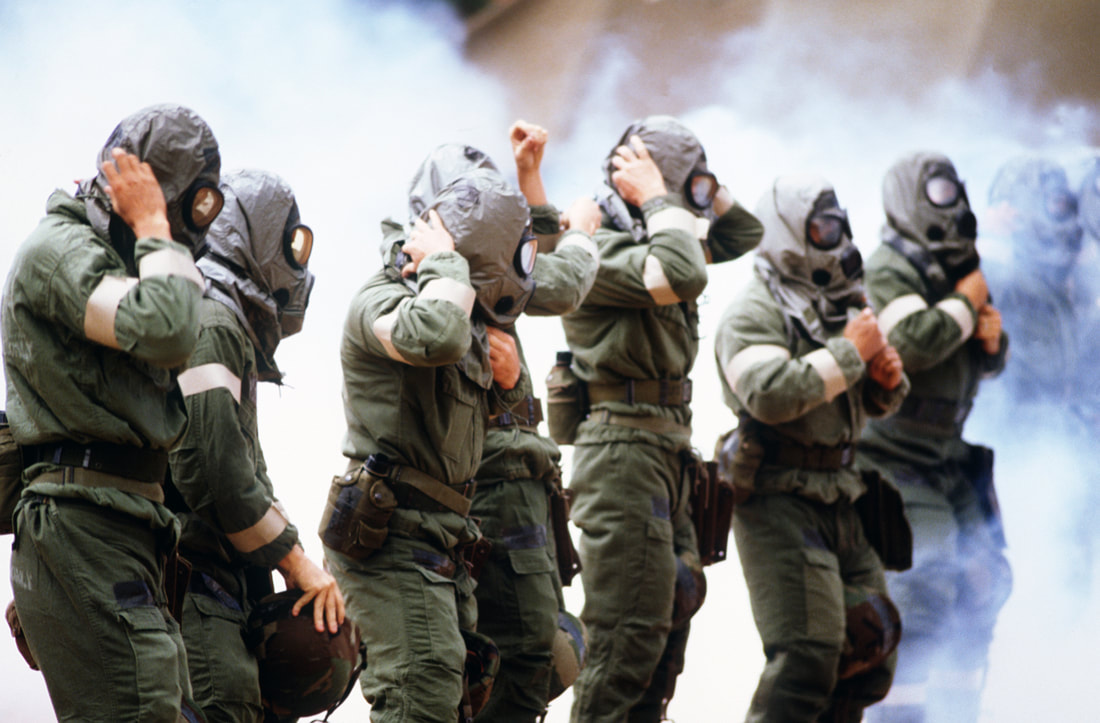 Image of Team members adjust their nuclear-biological-chemical warfare (NBC) headgear as they are exposed to tear gas during Exercise READINESS CHALLENGE 87