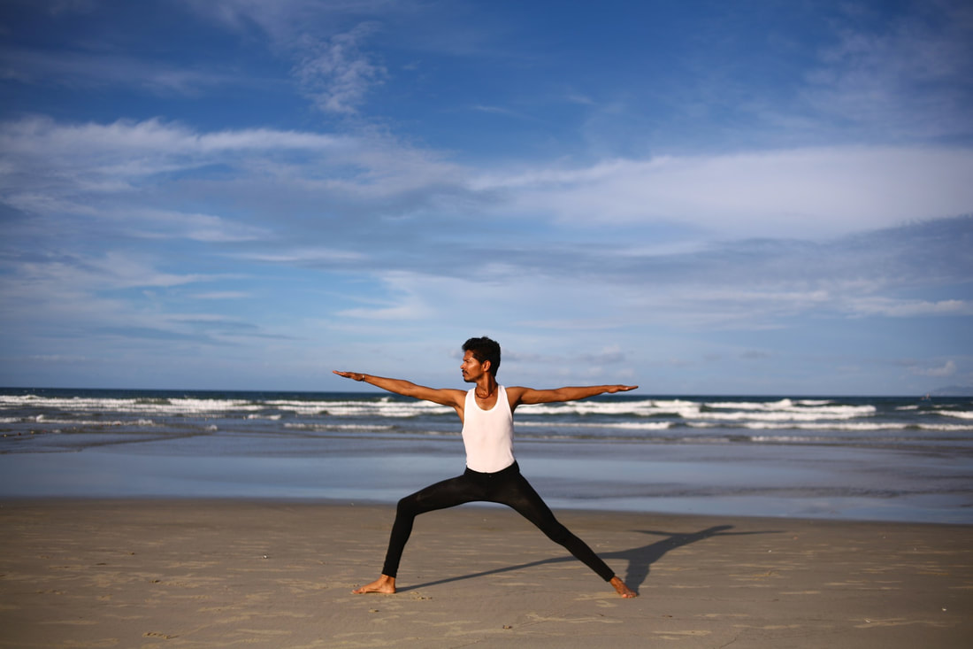 Image of a man practicing yoga on the beach